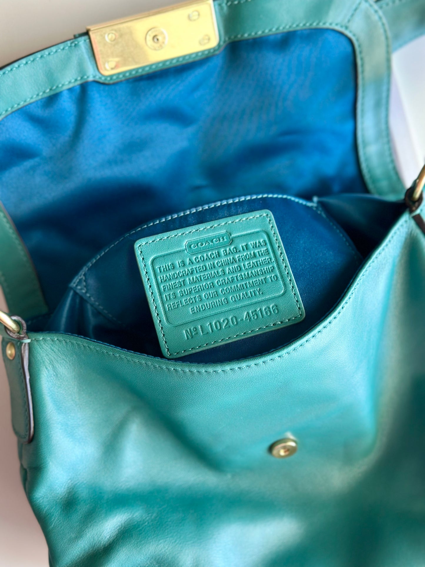 Vintage Coach leather bag in a striking turquoise-green
