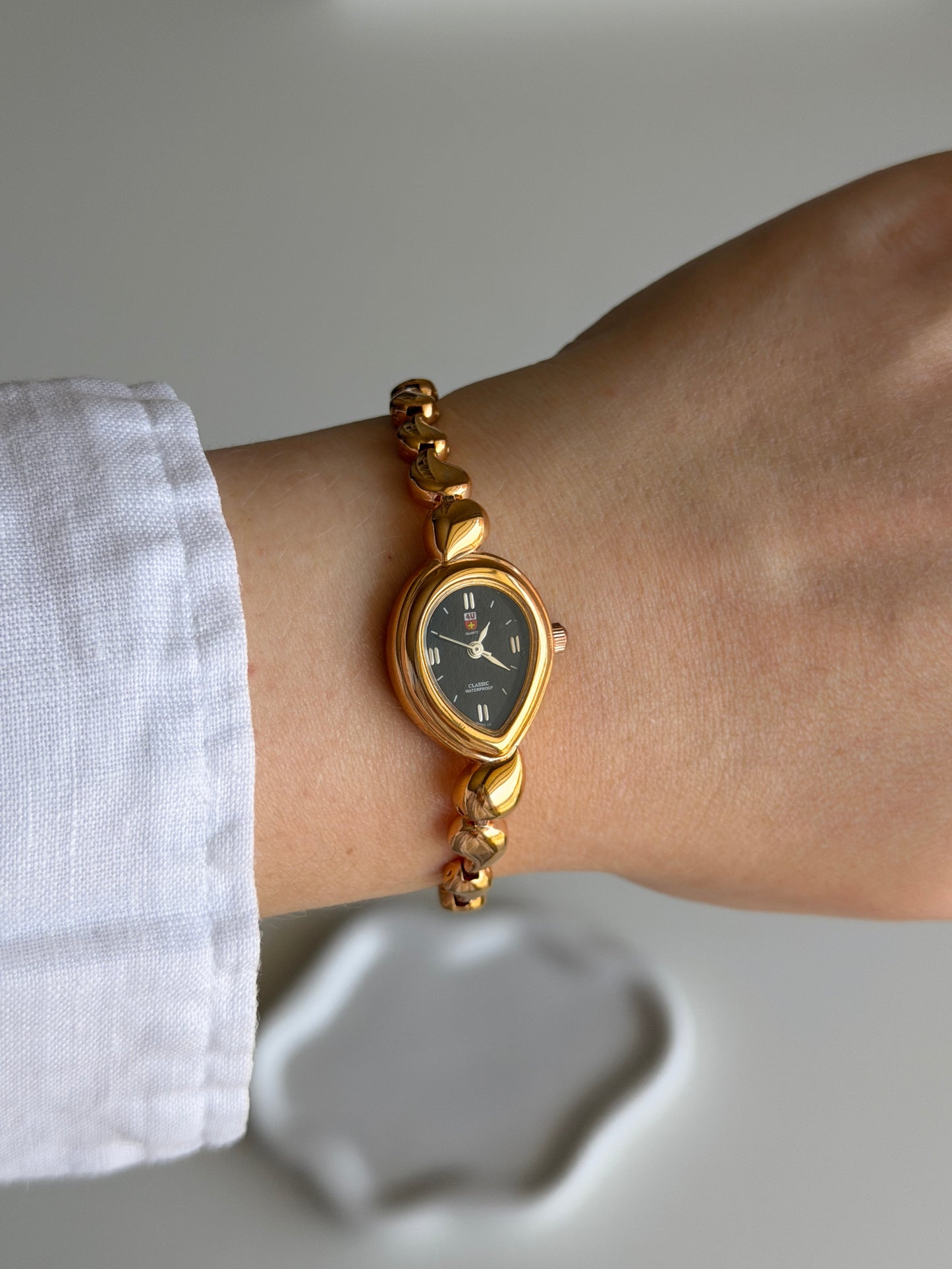 Vintage gold-tone watch with a striking black dial