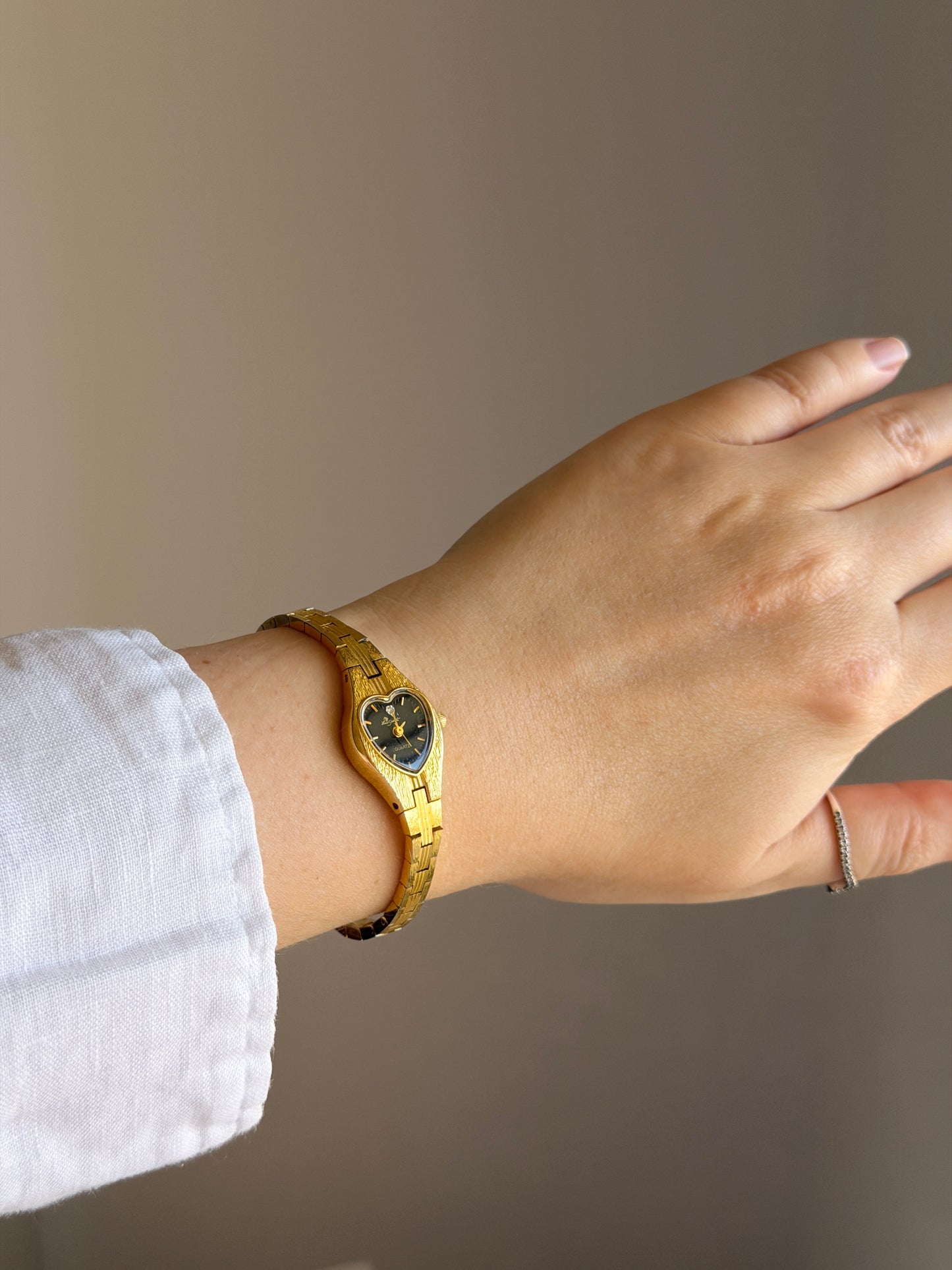Vintage gold-tone watch with black heart dial