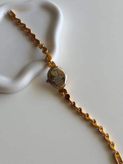 Vintage gold-tone watch with a striking black dial