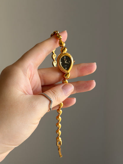 Vintage gold-tone watch with a striking black dial