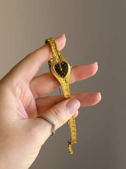 Vintage gold-tone watch with black heart dial