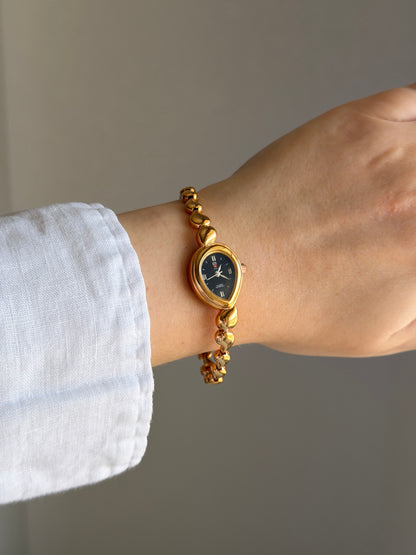 Vintage gold-tone watch with a striking black dial