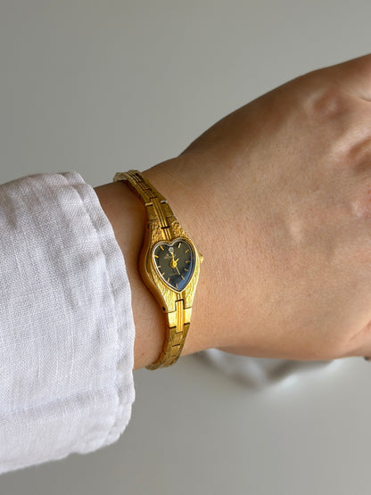 Vintage gold-tone watch with black heart dial