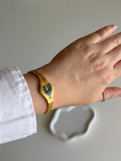 Vintage gold-tone watch with black heart dial