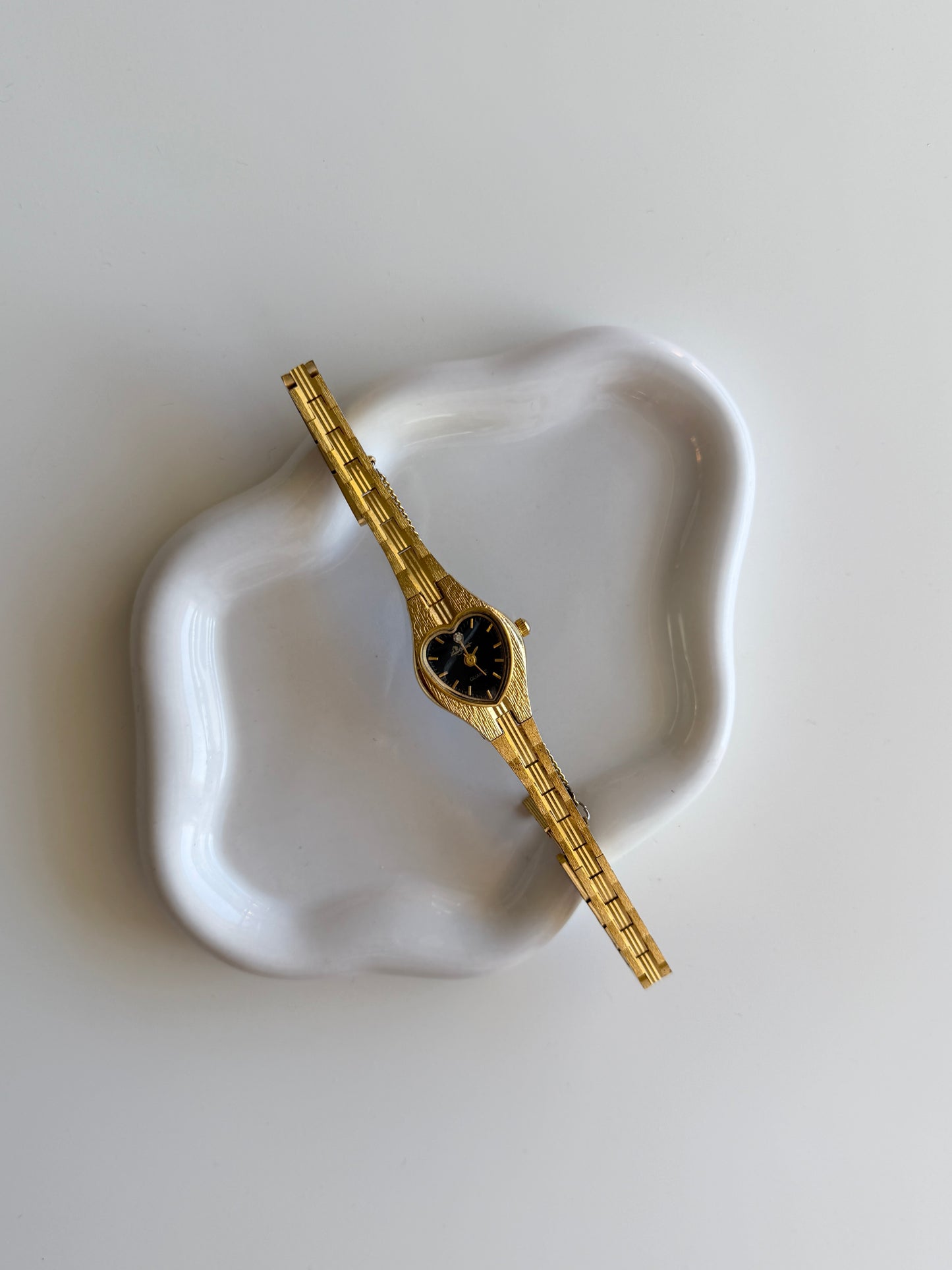 Vintage gold-tone watch with black heart dial